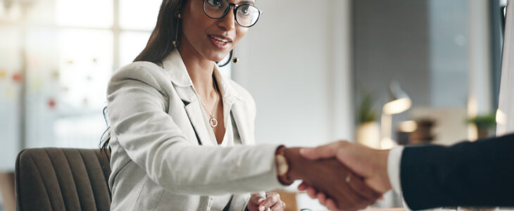 Business woman shaking hands with a man not in frame