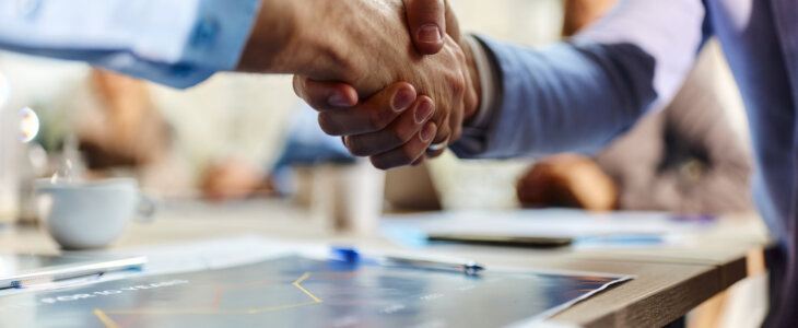 Close up of unrecognizable male entrepreneurs shaking hands during a meeting