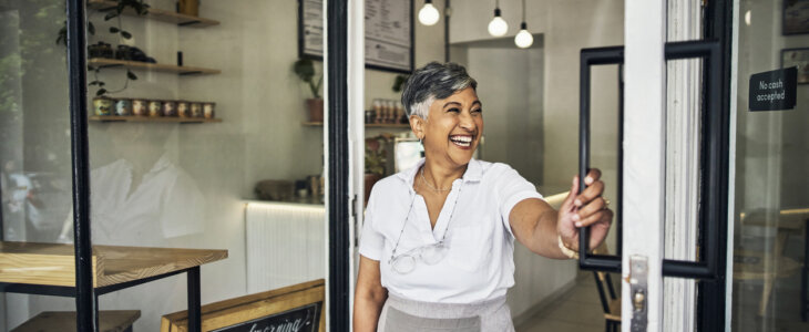 Small business, woman and coffee shop front door with pride for startup, cafe or restaurant.