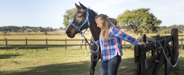 Woman entering in the round pen with her horse